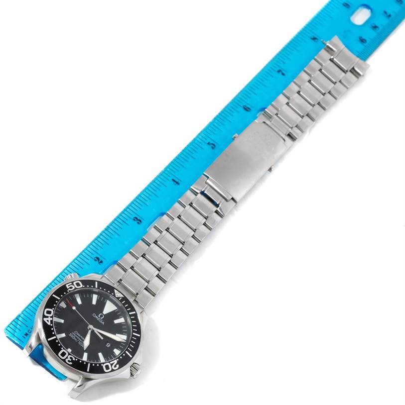 The Omega Seamaster 2264.50.00 Men's Stainless Steel Black Dial 2264.50.00 Men's Stainless Steel Black Dial watch is shown from a top-down angle, highlighting the dial, bezel, and metal bracelet alongside a ruler.