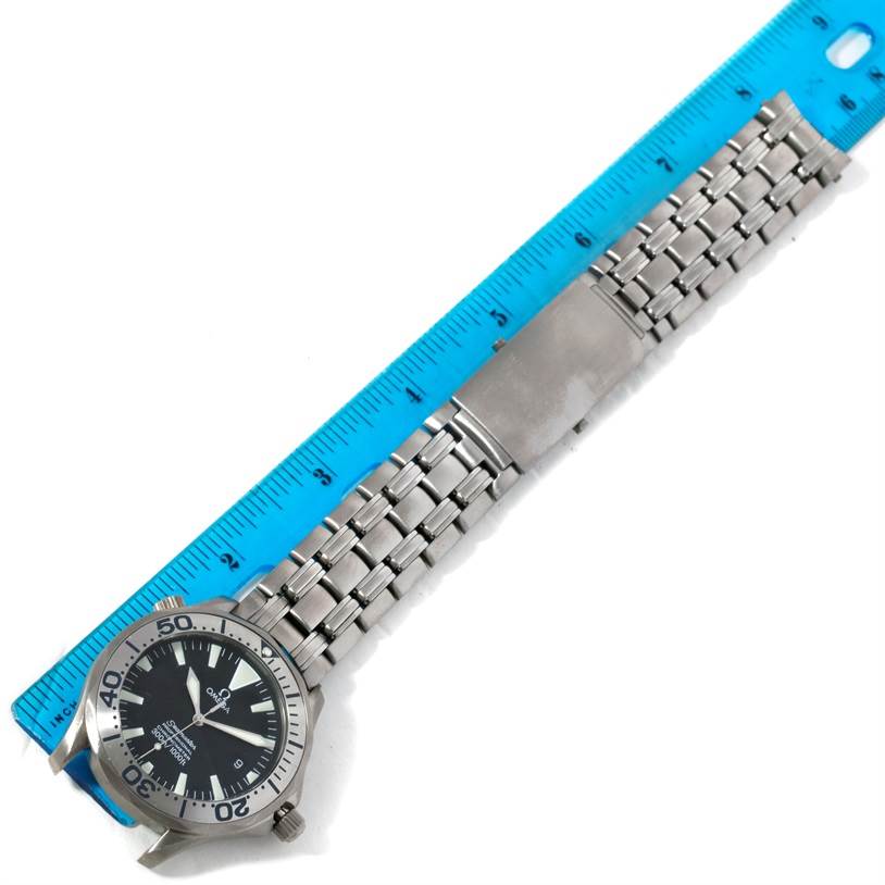 The Omega Seamaster 2031.50.00 Men's Titanium Black Dial 2031.50.00 Men's Titanium Black Dial watch is shown from above, displaying its face, bezel, and stainless steel bracelet with a measuring ruler alongside.