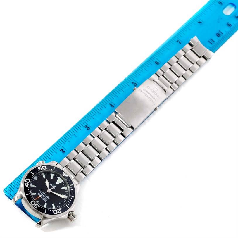 The image shows an Omega Seamaster 2252.50.00 Stainless Steel Black Dial 2252.50.00 Stainless Steel Black Dial watch with a stainless steel bracelet and clasp, measured against a blue ruler.