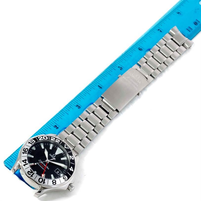 The Omega Seamaster 2534.50.00 Men
s Stainless Steel Black Dial 2534.50.00 Men
s Stainless Steel Black Dial model watch is shown from a top-down angle, highlighting its complete face, bezel, and bracelet next to a ruler.