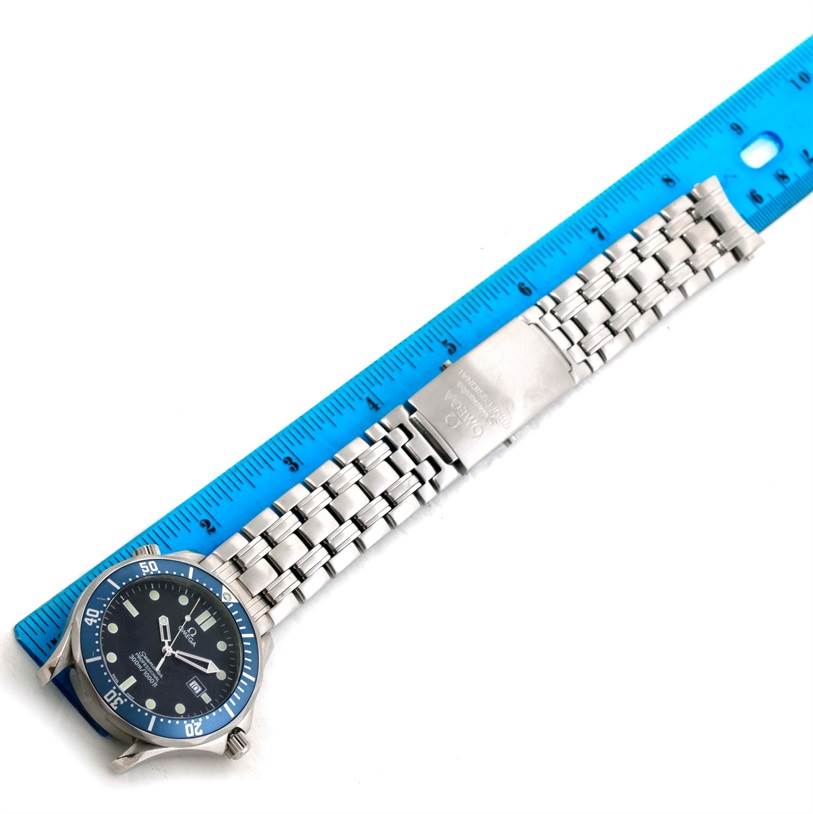 The image shows an Omega Seamaster 2541.80.00 Men
s Stainless Steel Blue Dial 2541.80.00 Men
s Stainless Steel Blue Dial watch laid flat next to a blue ruler, displaying the face and metal bracelet.