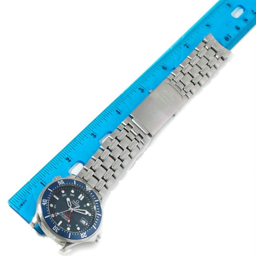 The image shows an Omega Seamaster 2535.80.00 Men's Stainless Steel Blue Dial 2535.80.00 Men's Stainless Steel Blue Dial watch laid flat with its bracelet extended next to a blue ruler.