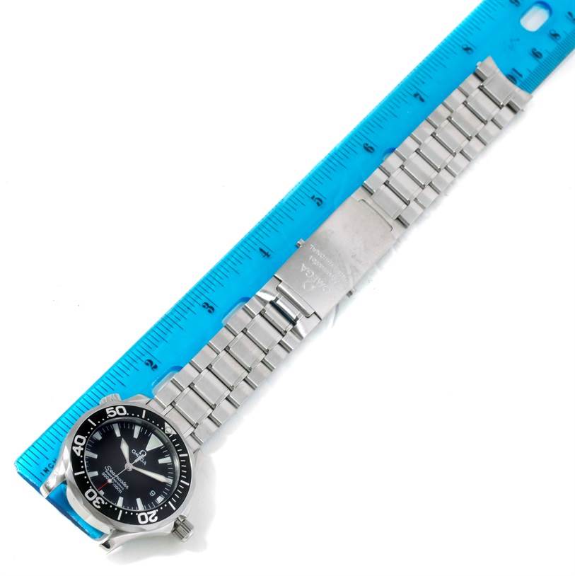 The image shows an Omega Seamaster 2262.50.00 Men
s Stainless Steel Black Dial 2262.50.00 Men
s Stainless Steel Black Dial watch laying flat along a blue ruler, displaying its face and metal bracelet.