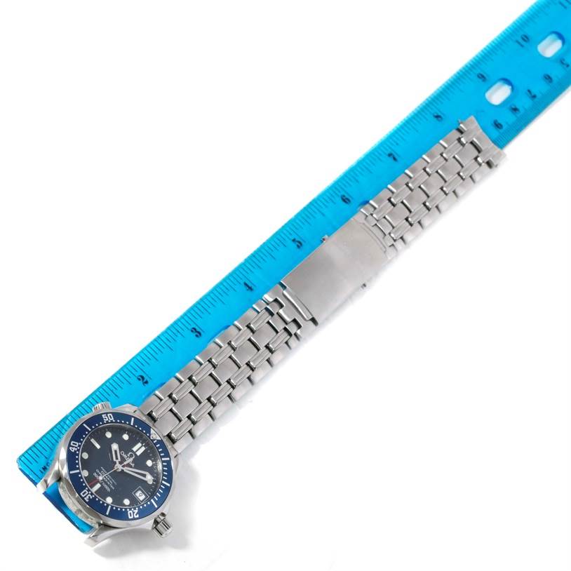 The image shows an Omega Seamaster 2222.80.00 Men
s Stainless Steel Blue Dial 2222.80.00 Men
s Stainless Steel Blue Dial watch laying flat next to a blue ruler, emphasizing its stainless steel bracelet and clasp.