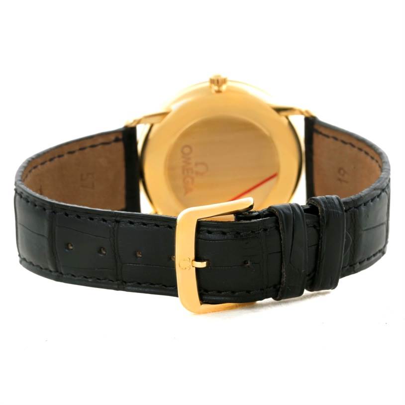 This image shows the back of an Omega De Ville 4620.31 Men's Yellow Gold Silver Dial 4620.31 Men's Yellow Gold Silver Dial watch and its black leather strap with a gold buckle.