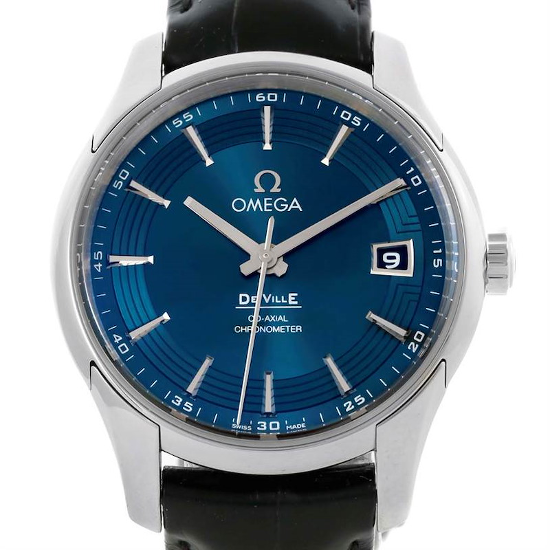 The image shows a front view of an Omega De Ville watch, highlighting its blue dial, hands, hour markers, and date window.