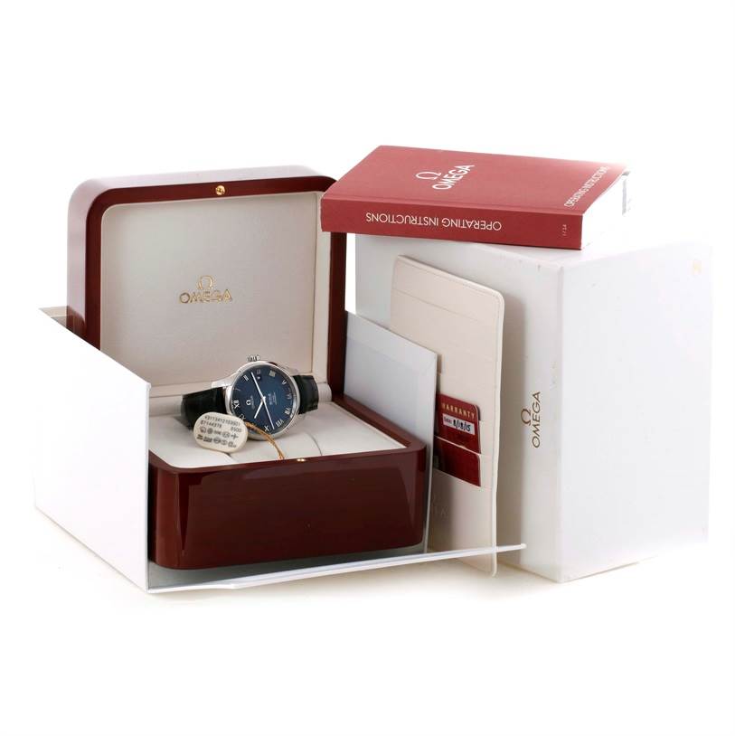 The Omega De Ville 431.13.41.21.03.001 Men's Stainless Steel Blue Dial 431.13.41.21.03.001 Men's Stainless Steel Blue Dial watch is displayed in its open box packaging along with an instruction manual and warranty cards nearby.