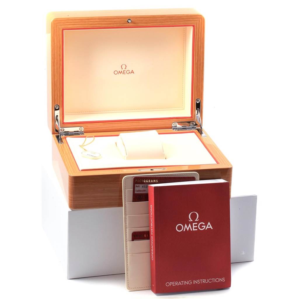 The image shows a De Ville model Omega watch box with operating instructions and warranty cards.