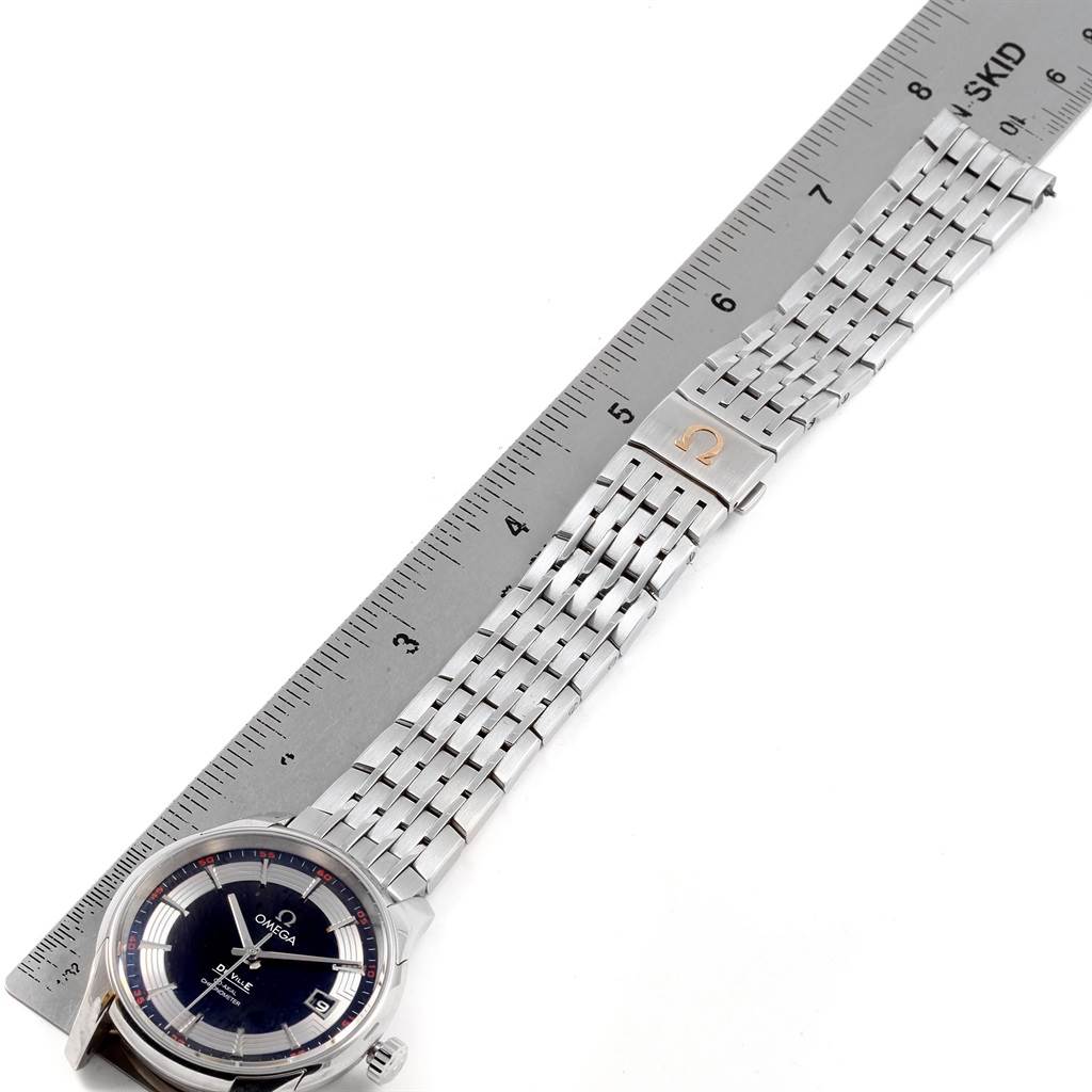 The image shows an Omega De Ville 431.30.41.21.01.001 Men
s Stainless Steel Black Dial 431.30.41.21.01.001 Men
s Stainless Steel Black Dial watch at an angled top view, highlighting the face, bezel, and metal bracelet alongside a ruler for scale.