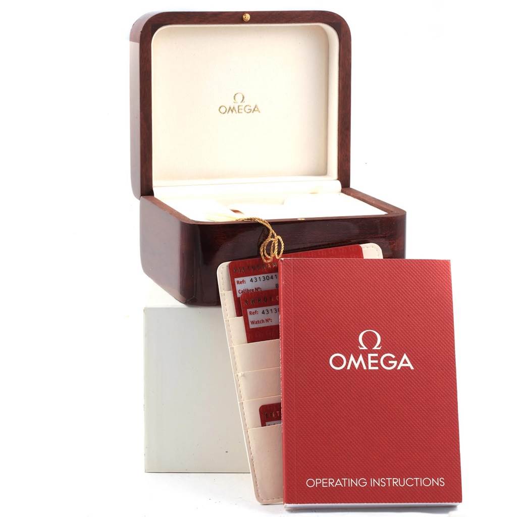 The image shows the Omega De Ville 431.30.41.21.01.001 Men
s Stainless Steel Black Dial 431.30.41.21.01.001 Men
s Stainless Steel Black Dial watch box, operating instructions booklet, and cardholder with cards.