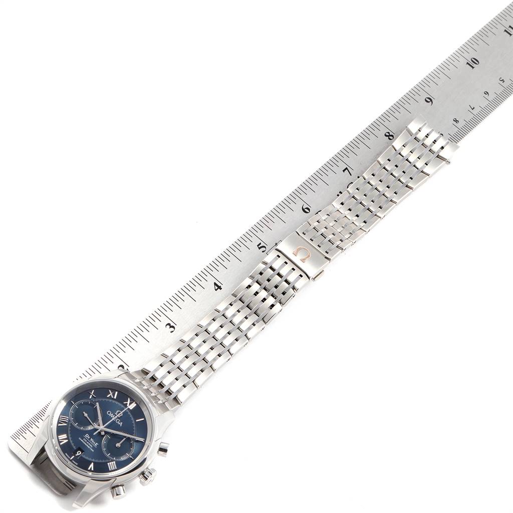 The image shows an Omega De Ville 431.10.42.51.03.001 Men's Stainless Steel Blue Dial 431.10.42.51.03.001 Men's Stainless Steel Blue Dial watch laid flat with its band extended alongside a ruler for measurement.