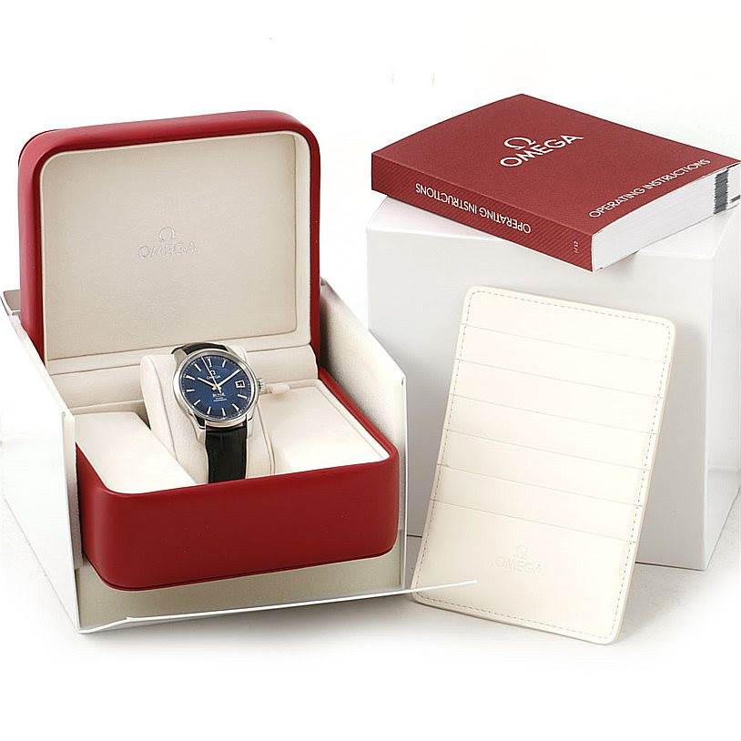 The Omega De Ville 431.33.41.21.03.001 Men
s Stainless Steel Blue Dial 431.33.41.21.03.001 Men
s Stainless Steel Blue Dial watch is displayed at a front angle with its box, instruction manual, and warranty card holder.