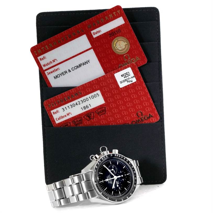 The image shows an Omega Speedmaster 311.30.42.30.01.005 Men
s Stainless Steel Black Dial 311.30.42.30.01.005 Men
s Stainless Steel Black Dial watch with warranty cards and a black cardholder viewed from a tilted angle.
