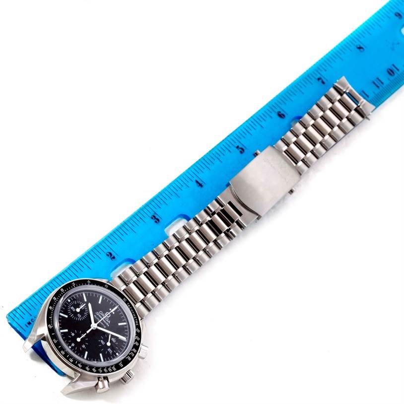 The image shows an Omega Speedmaster 3539.50.00 Men
s Stainless Steel Black Dial 3539.50.00 Men
s Stainless Steel Black Dial watch laid flat with a blue ruler next to it for measurement.