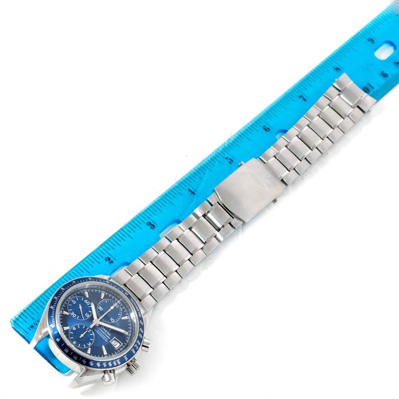 The Omega Speedmaster 3212.80.00 Men
s Stainless Steel Blue Dial 3212.80.00 Men
s Stainless Steel Blue Dial watch is shown laid flat with a metal bracelet and a blue ruler for measurement.
