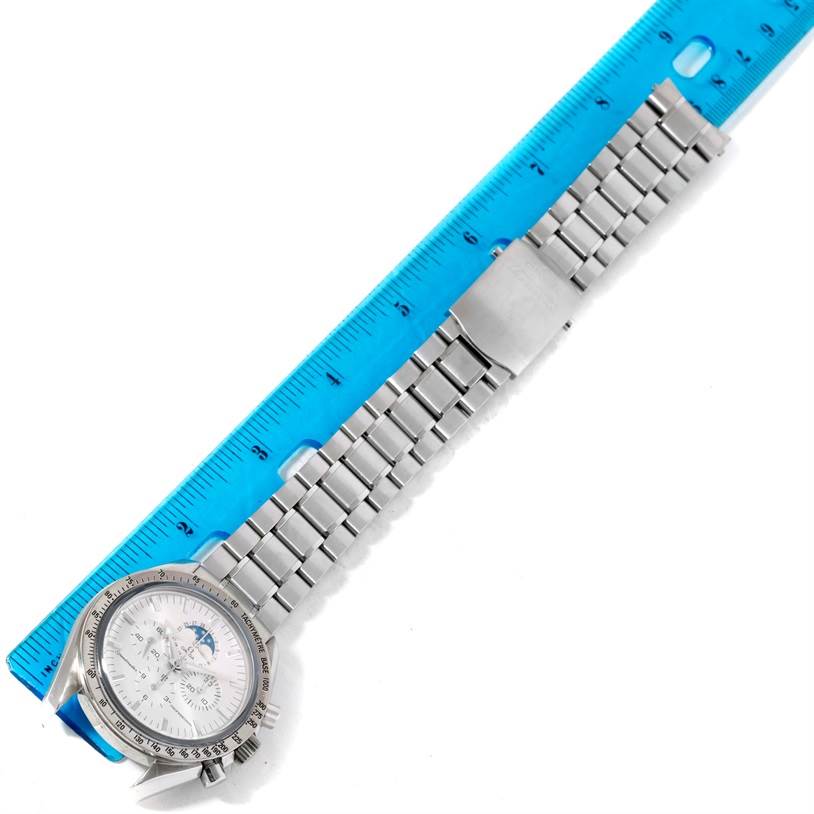 The image shows an Omega Speedmaster 3575.30.00 Men
s Stainless Steel Silver Dial 3575.30.00 Men
s Stainless Steel Silver Dial watch laid flat next to a blue ruler, highlighting the face and band.