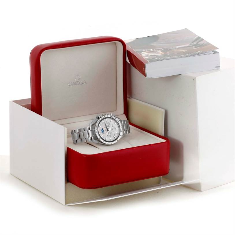 This image shows an Omega Speedmaster 3575.30.00 Men
s Stainless Steel Silver Dial 3575.30.00 Men
s Stainless Steel Silver Dial watch placed inside its open red box, with a booklet to the side.