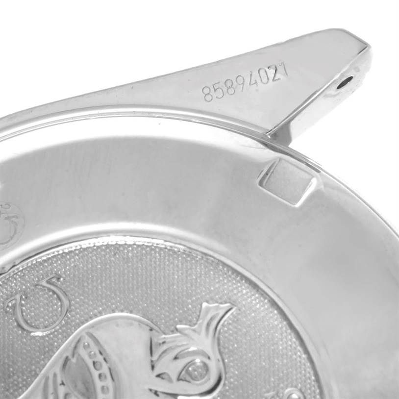 The image shows a close-up of the Omega Speedmaster 3220.50.00 Men
s Stainless Steel Black Dial 3220.50.00 Men
s Stainless Steel Black Dial
s case back featuring engravings and embossed design elements.