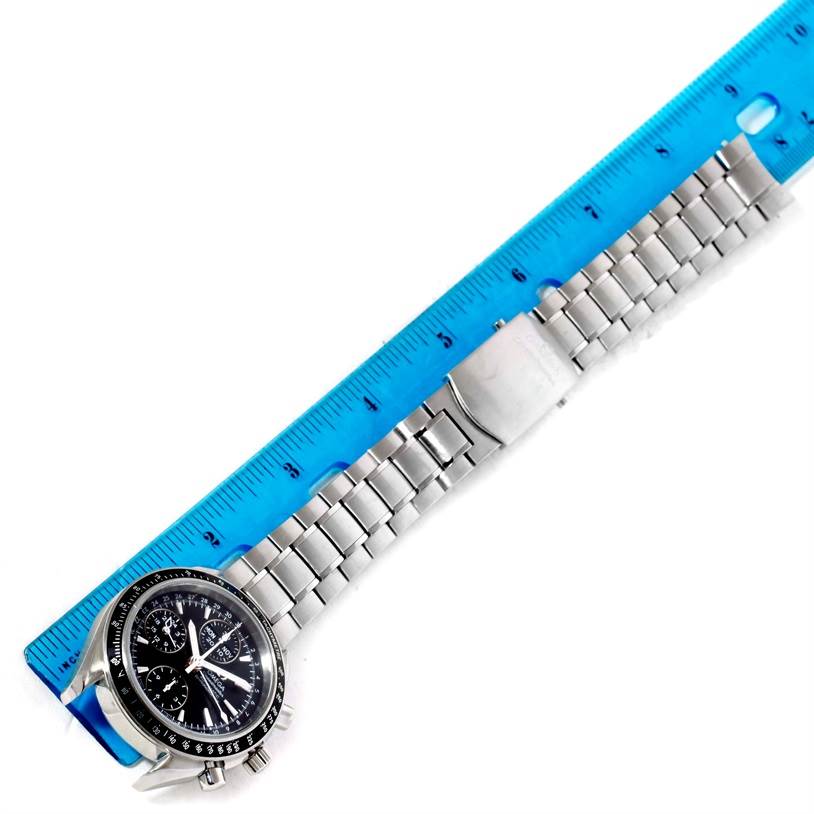 The image shows an Omega Speedmaster 3220.50.00 Men
s Stainless Steel Black Dial 3220.50.00 Men
s Stainless Steel Black Dial watch laid flat next to a blue ruler for measurement, highlighting its stainless steel bracelet and black dial.