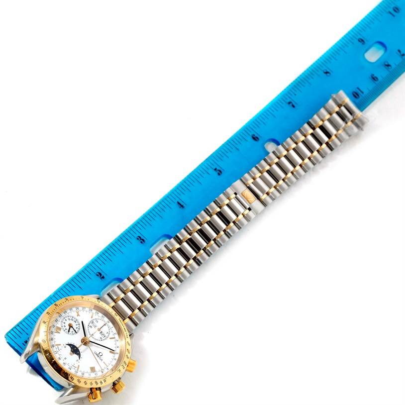 The image shows an Omega Speedmaster 3330.20.00 Men
s Stainless Steel White Dial 3330.20.00 Men
s Stainless Steel White Dial watch placed next to a ruler with a focus on the metal bracelet and the face at the left side.