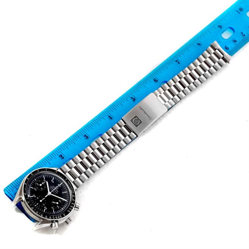 The Omega Speedmaster 3510.50.00 Men
s Stainless Steel Black Dial 3510.50.00 Men
s Stainless Steel Black Dial watch is shown flat with its bracelet extended, placed alongside a blue ruler for scale.