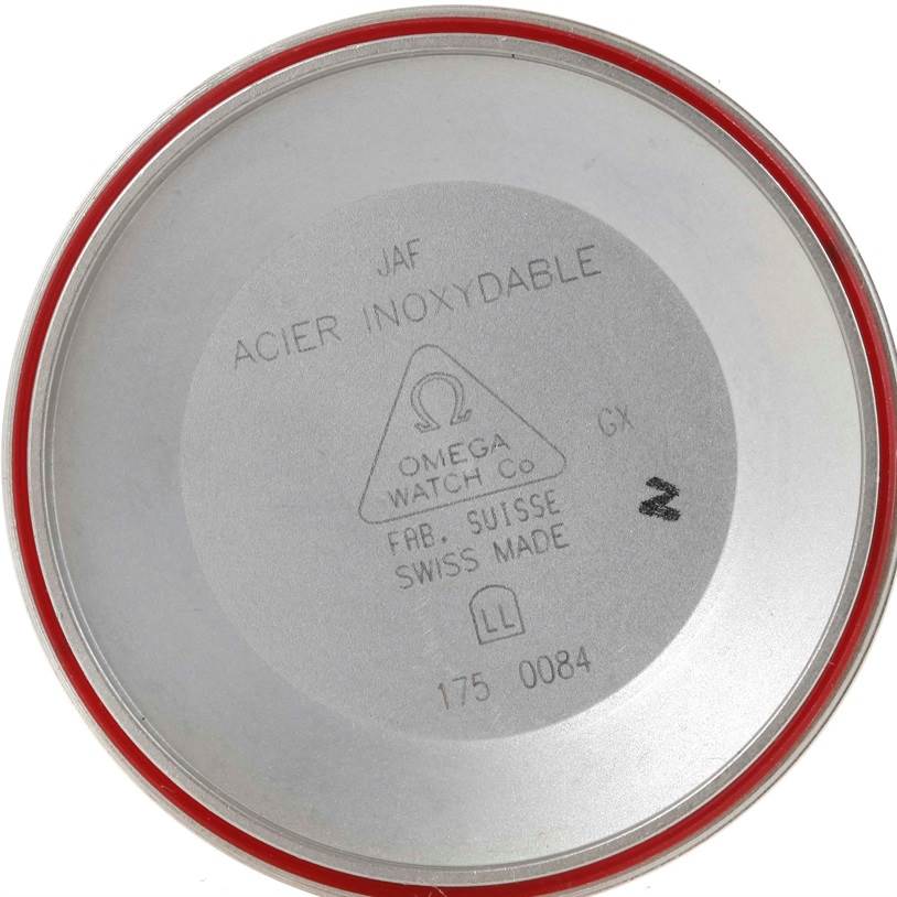 The image shows the inside back cover of an Omega Speedmaster 3520.50.00 Men
s Stainless Steel Black Dial 3520.50.00 Men
s Stainless Steel Black Dial watch, including its seal and engravings.