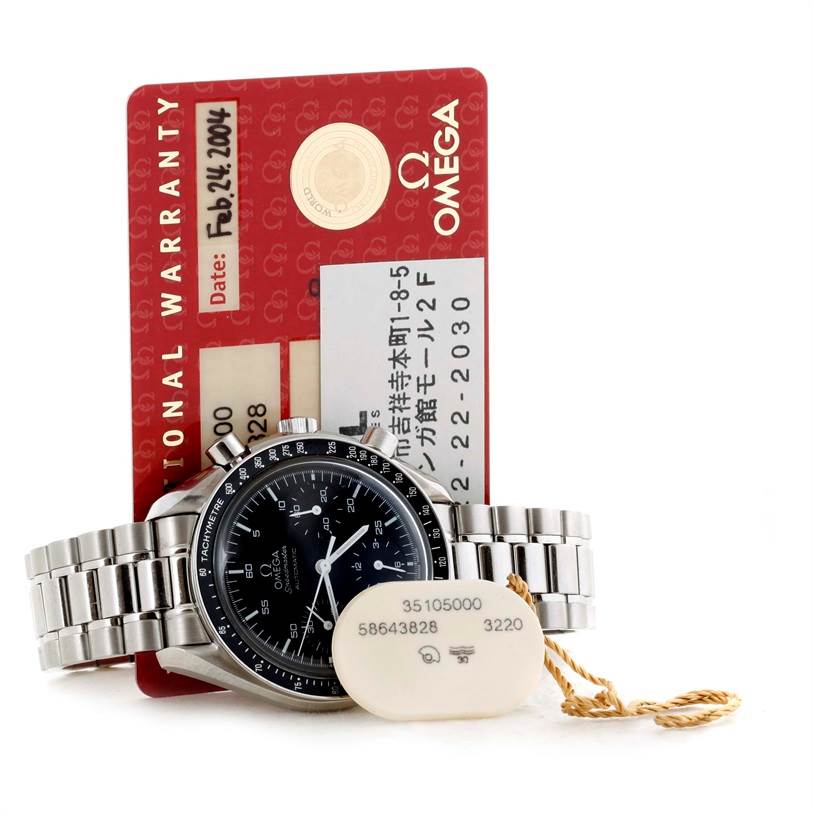 This image shows the Omega Speedmaster 3510.50.00 Men
s Stainless Steel Black Dial 3510.50.00 Men
s Stainless Steel Black Dial watch along with its warranty card and a tag attached, photographed from the front.
