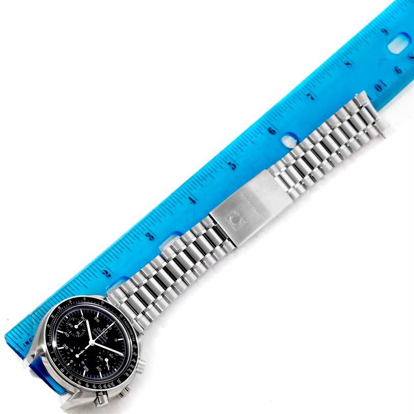 The Omega Speedmaster 3510.50.00 Men
s Stainless Steel Black Dial 3510.50.00 Men
s Stainless Steel Black Dial watch is shown face-up with its metal bracelet extended next to a blue ruler.