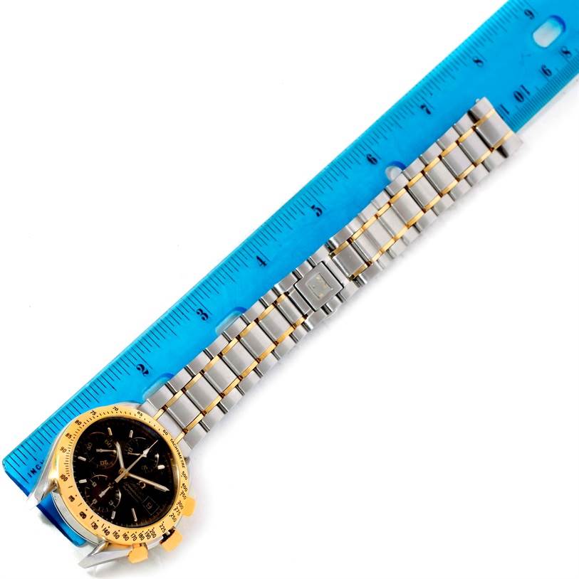 The image shows an Omega Speedmaster 3313.50.00 Men's Steel and Gold (two tone) Black Dial 3313.50.00 Men's Steel and Gold (two tone) Black Dial watch face and metal band, placed alongside a blue measuring ruler.