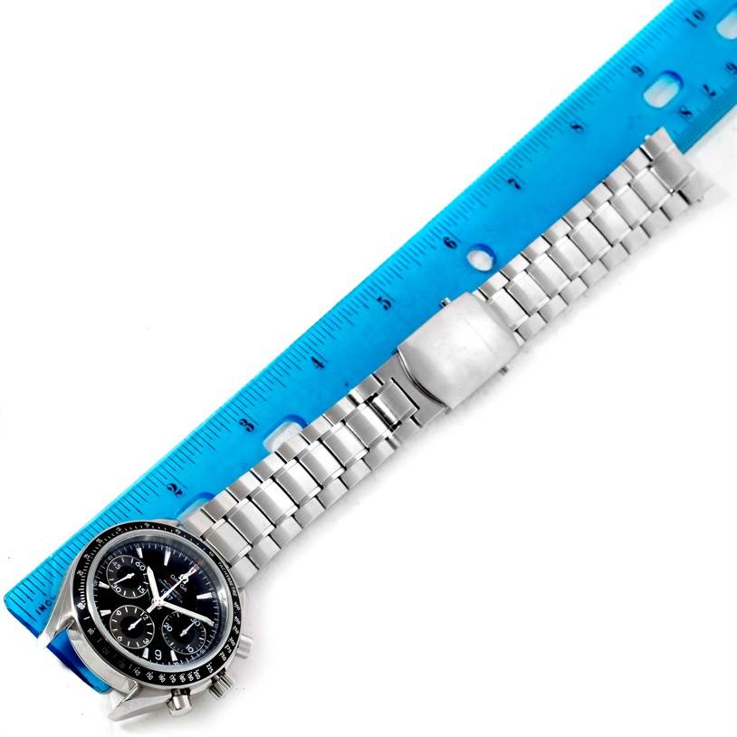 The image shows an Omega Speedmaster 323.30.40.40.01.001 Men
s Stainless Steel Black Dial 323.30.40.40.01.001 Men
s Stainless Steel Black Dial watch with a metal bracelet, placed alongside a blue ruler for size reference.