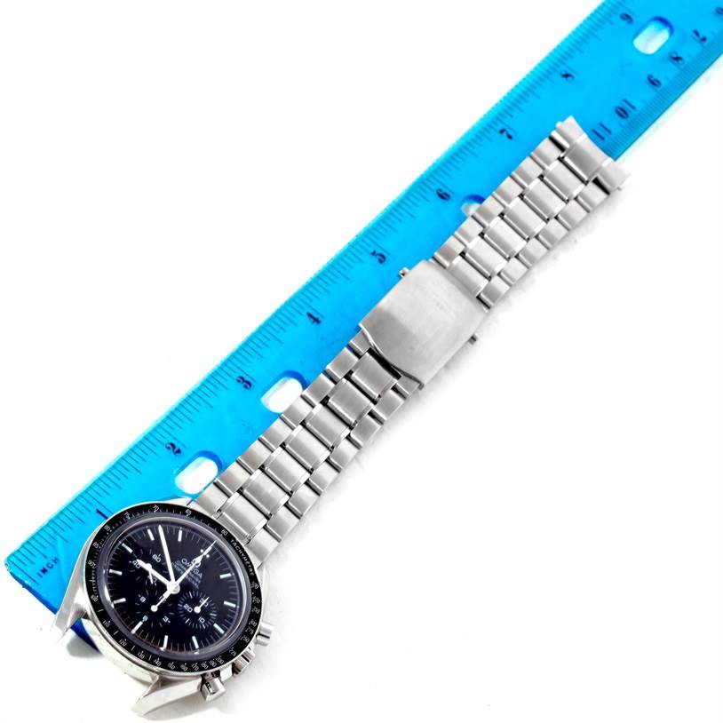 The Omega Speedmaster 3573.50.00 Men
s Stainless Steel Black Dial 3573.50.00 Men
s Stainless Steel Black Dial watch is shown diagonally with its bracelet and clasp alongside a blue ruler for size comparison.