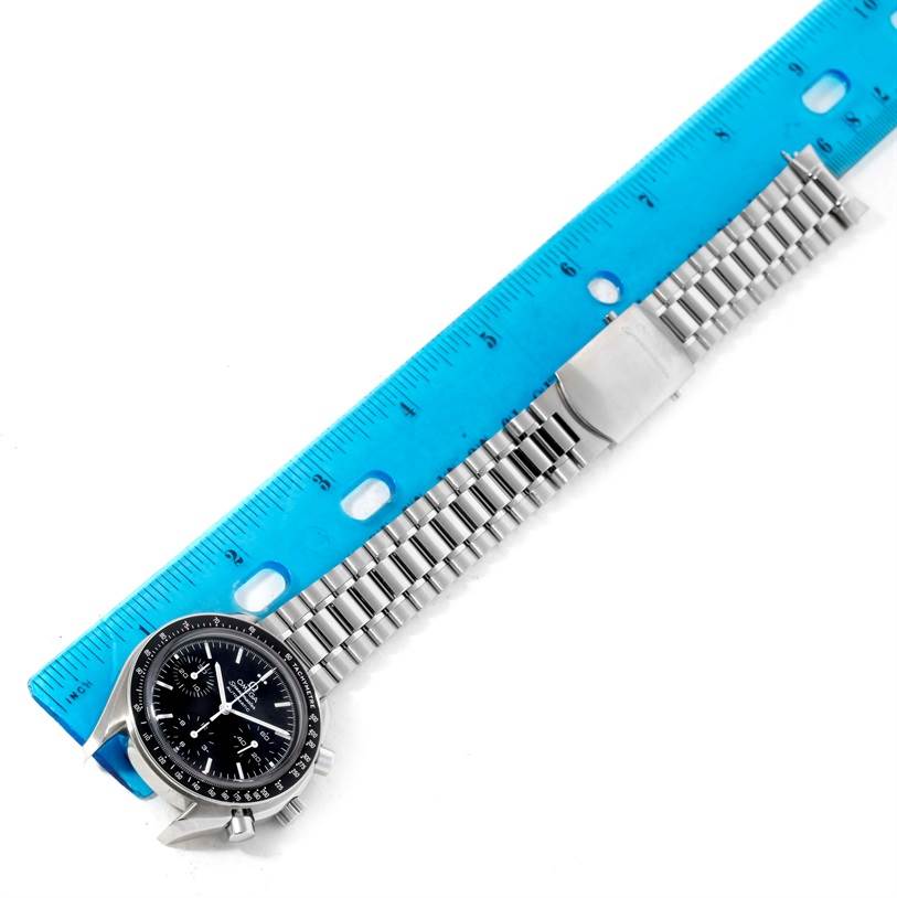 The image shows an Omega Speedmaster 3539.50.00 Men
s Stainless Steel Black Dial 3539.50.00 Men
s Stainless Steel Black Dial watch laid flat with a blue ruler alongside it for measurement.