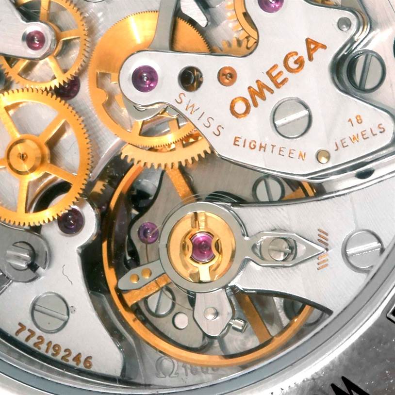 Close-up angle of the Omega Speedmaster 3573.50.00 Men
s Stainless Steel Black Dial 3573.50.00 Men
s Stainless Steel Black Dial watch movement, showcasing gears and the "SWISS EIGHTEEN JEWELS" inscription.