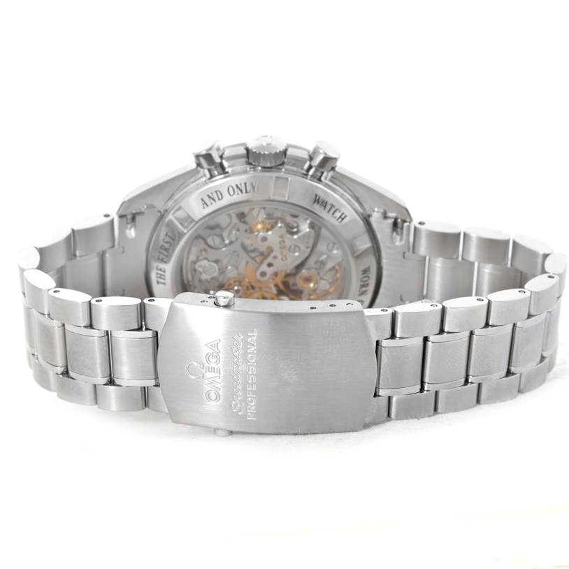 The image shows the back view of an Omega Speedmaster 3573.50.00 Men
s Stainless Steel Black Dial 3573.50.00 Men
s Stainless Steel Black Dial watch, highlighting the clasp, bracelet, and transparent case back.