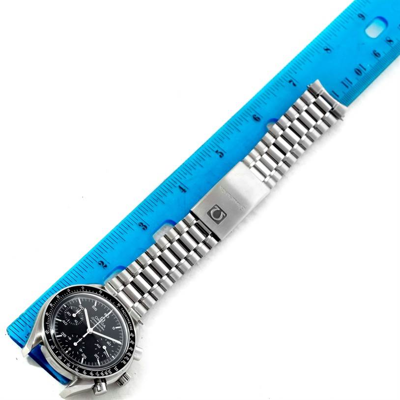 The Omega Speedmaster 3510.50.00 Men
s Stainless Steel Black Dial 3510.50.00 Men
s Stainless Steel Black Dial watch, including its face and metal bracelet, is shown horizontally next to a ruler for scale.