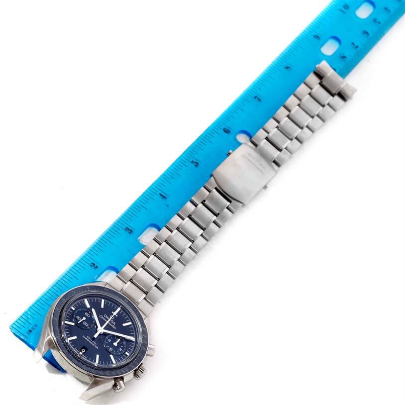 The Omega Speedmaster 311.90.44.51.03.001 Men
s Titanium Blue Dial 311.90.44.51.03.001 Men
s Titanium Blue Dial watch is shown from an overhead angle, with its wristband aligned next to a blue ruler.