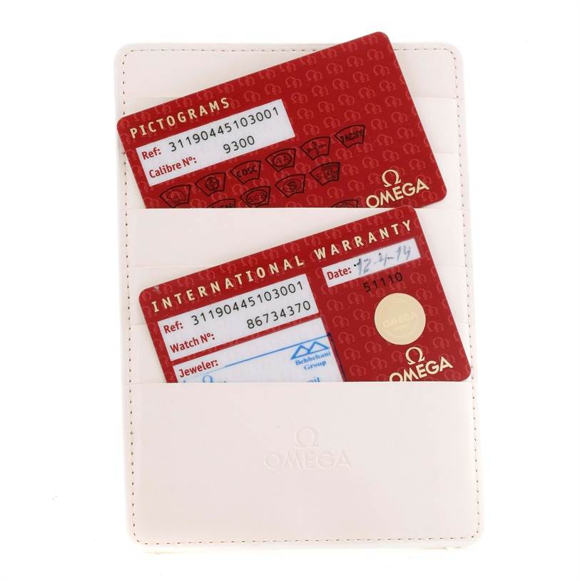 The image shows warranty and pictogram cards for an Omega Speedmaster 311.90.44.51.03.001 Men
s Titanium Blue Dial 311.90.44.51.03.001 Men
s Titanium Blue Dial watch in a white cardholder.