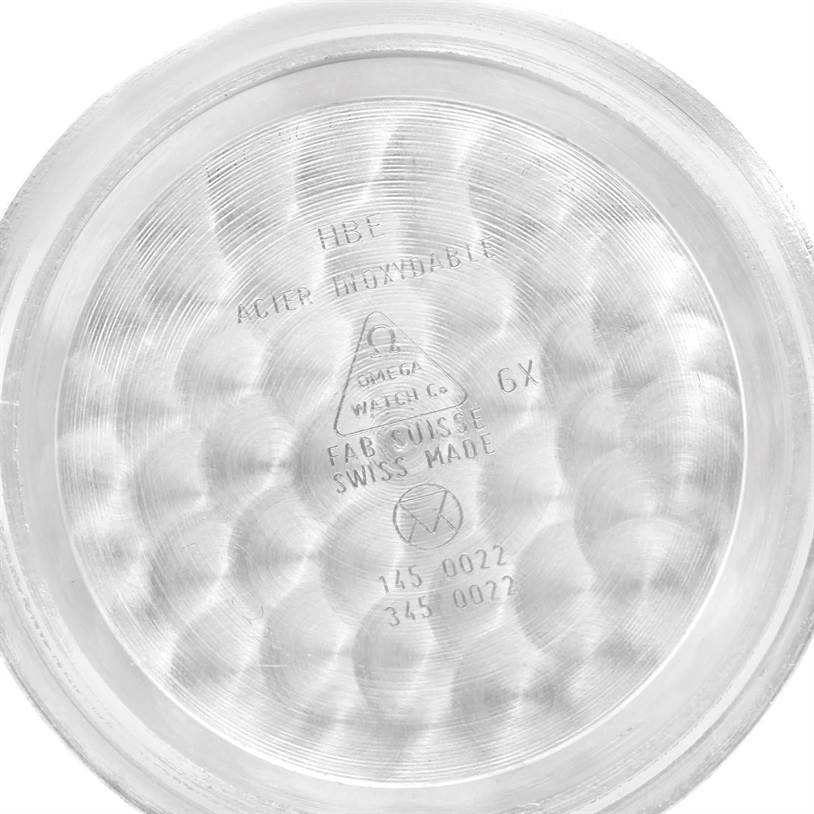 This image shows the inside case back of an Omega Speedmaster Men
s Stainless Steel Black Dial Men
s Stainless Steel Black Dial watch, with engravings and markings visible.