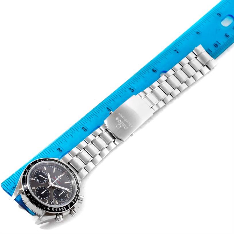 The image shows an Omega Speedmaster 323.30.40.40.06.001 Men
s Stainless Steel Black Dial 323.30.40.40.06.001 Men
s Stainless Steel Black Dial watch lying flat with a metal bracelet against a blue ruler for scale.