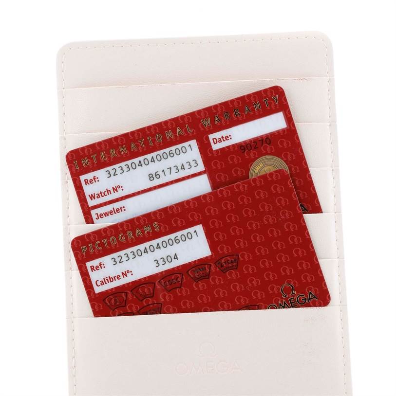 The image shows the international warranty and pictograms cards for the Omega Speedmaster 323.30.40.40.06.001 Men
s Stainless Steel Black Dial 323.30.40.40.06.001 Men
s Stainless Steel Black Dial model, held in a white cardholder.