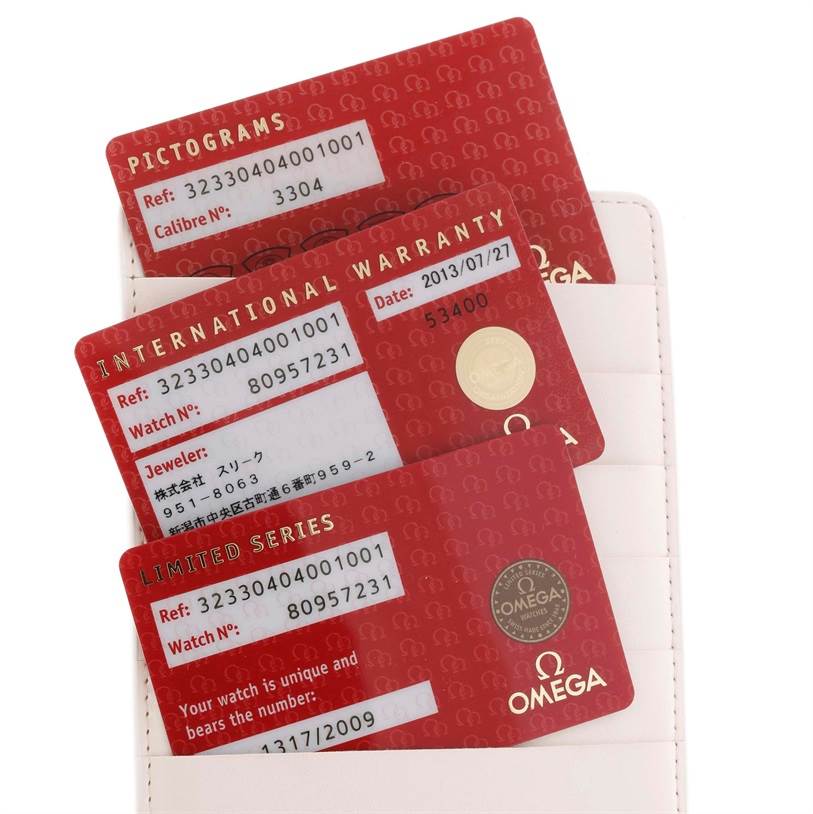 The image shows warranty and certification cards for an Omega Speedmaster 323.30.40.40.01.001 Men
s Stainless Steel Black Dial 323.30.40.40.01.001 Men
s Stainless Steel Black Dial watch, along with a card holder.