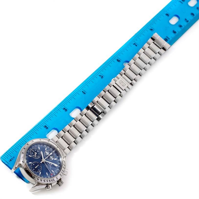 The image shows an Omega Speedmaster 3523.80.00 Men
s Stainless Steel Blue Dial 3523.80.00 Men
s Stainless Steel Blue Dial watch laid flat with the face and bracelet aligned with a blue ruler.