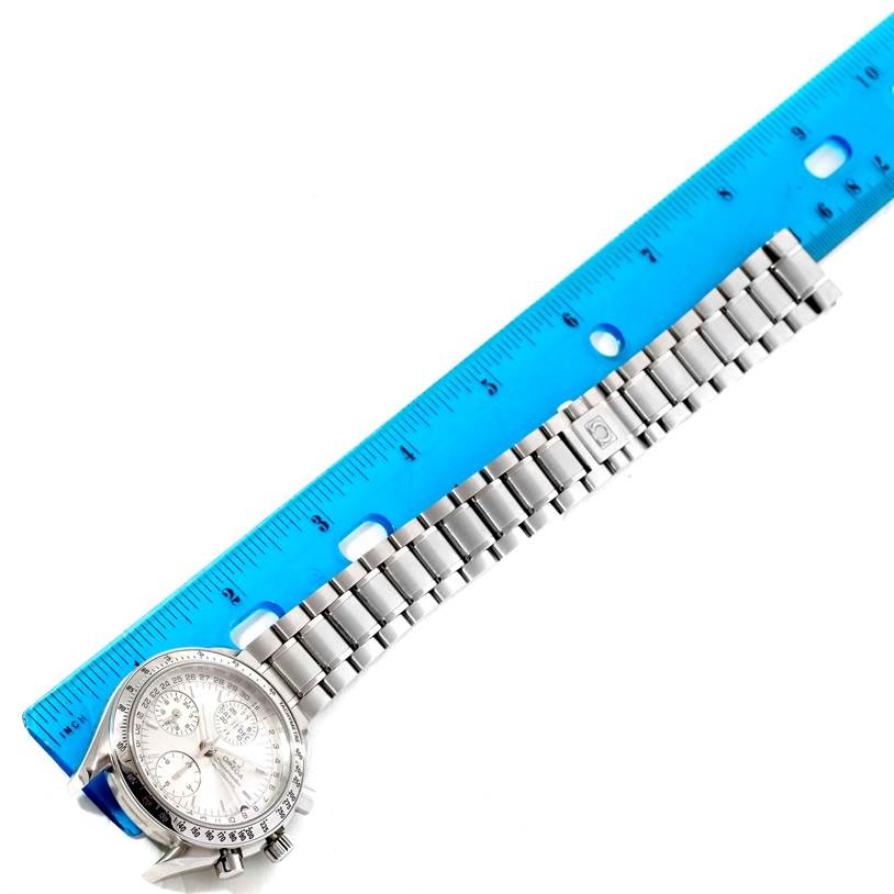The image shows an Omega Speedmaster 3523.30.00 Men
s Stainless Steel Silver Dial 3523.30.00 Men
s Stainless Steel Silver Dial watch with its bracelet laid flat next to a blue ruler.