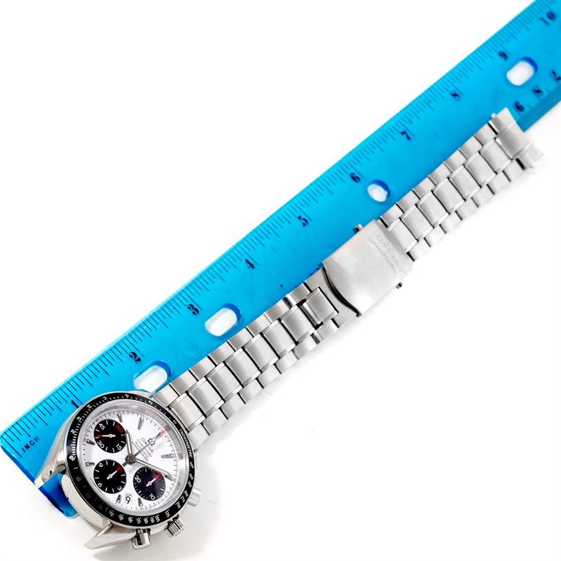 The image shows an Omega Speedmaster 323.30.40.40.04.001 Men
s Stainless Steel White Dial 323.30.40.40.04.001 Men
s Stainless Steel White Dial watch laying flat with a blue ruler measuring its metal bracelet.