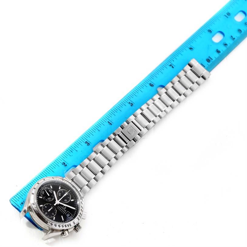The Omega Speedmaster 3513.50.00 Stainless Steel Black Dial 3513.50.00 Stainless Steel Black Dial watch is shown from a top-down angle, alongside a blue ruler, highlighting its face and stainless steel bracelet.