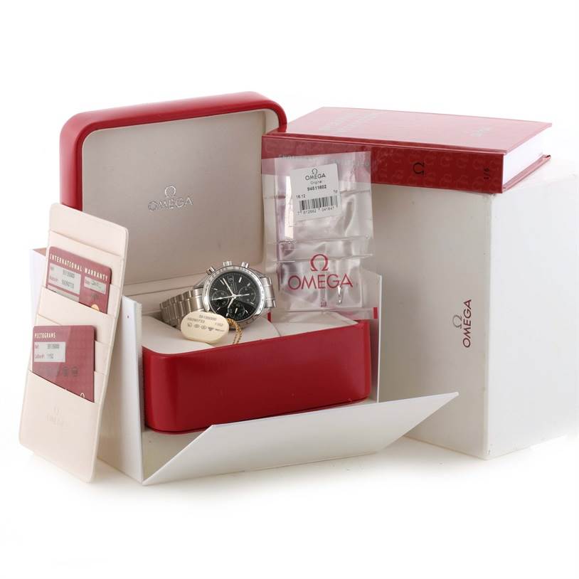 This image shows an Omega Speedmaster 3513.50.00 Men
s Stainless Steel Black Dial 3513.50.00 Men
s Stainless Steel Black Dial watch at an angle inside an open red case, along with warranty cards and booklets.