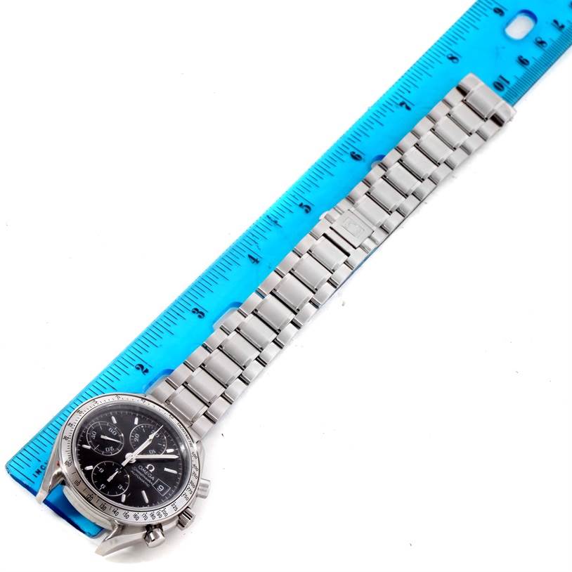 The Omega Speedmaster 3513.50.00 Men
s Stainless Steel Black Dial 3513.50.00 Men
s Stainless Steel Black Dial watch is shown from a top-down angle, displaying the entire face and metal band alongside a blue ruler for measurement.