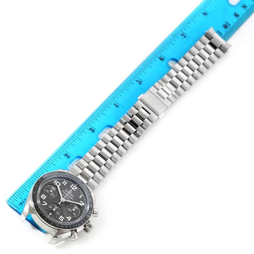 The image shows an Omega Speedmaster 324.30.38.40.06.001 Men
s Stainless Steel Grey Dial 324.30.38.40.06.001 Men
s Stainless Steel Grey Dial watch laid flat next to a blue ruler, displaying its face and bracelet.