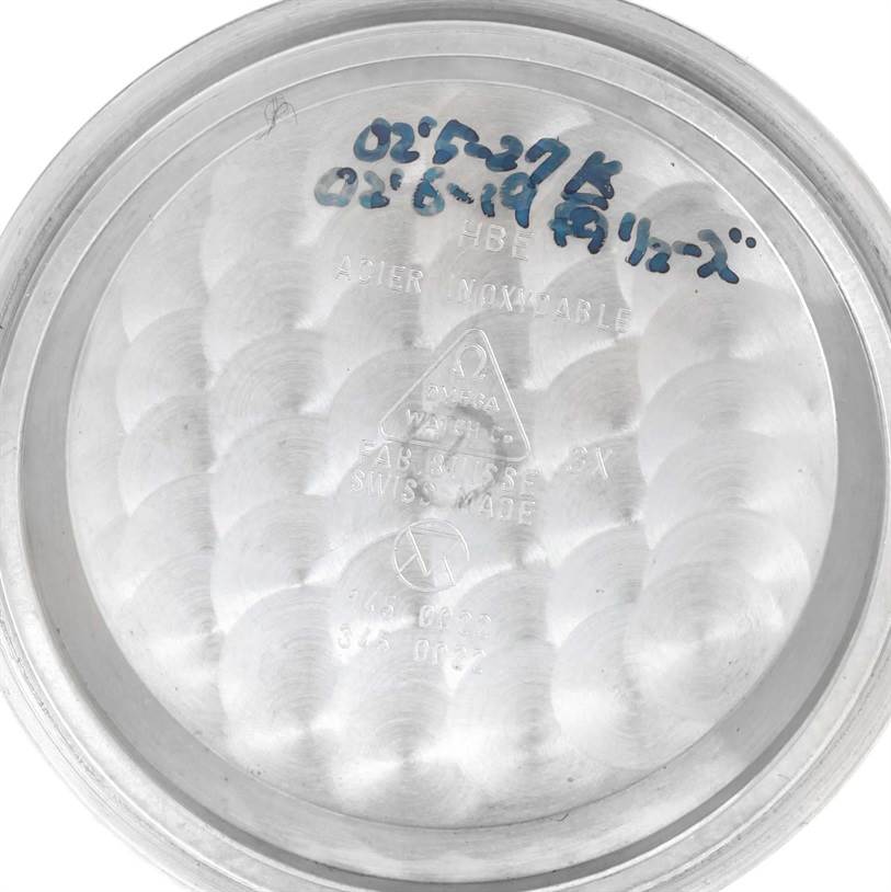 This image shows the inner case back of an Omega Speedmaster Men
s Stainless Steel Black Dial Men
s Stainless Steel Black Dial watch, featuring engravings and handwritten markings.