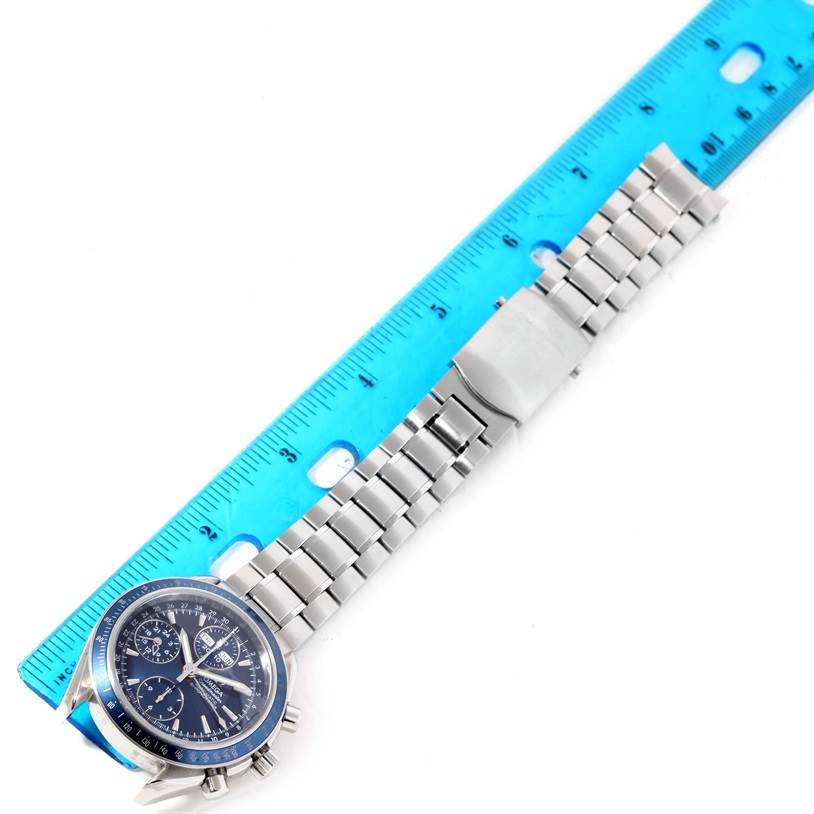 The image shows an Omega Speedmaster 3222.80.00 Men
s Stainless Steel Blue Dial 3222.80.00 Men
s Stainless Steel Blue Dial watch laid flat alongside a blue ruler, displaying the face, bracelet, and clasp.